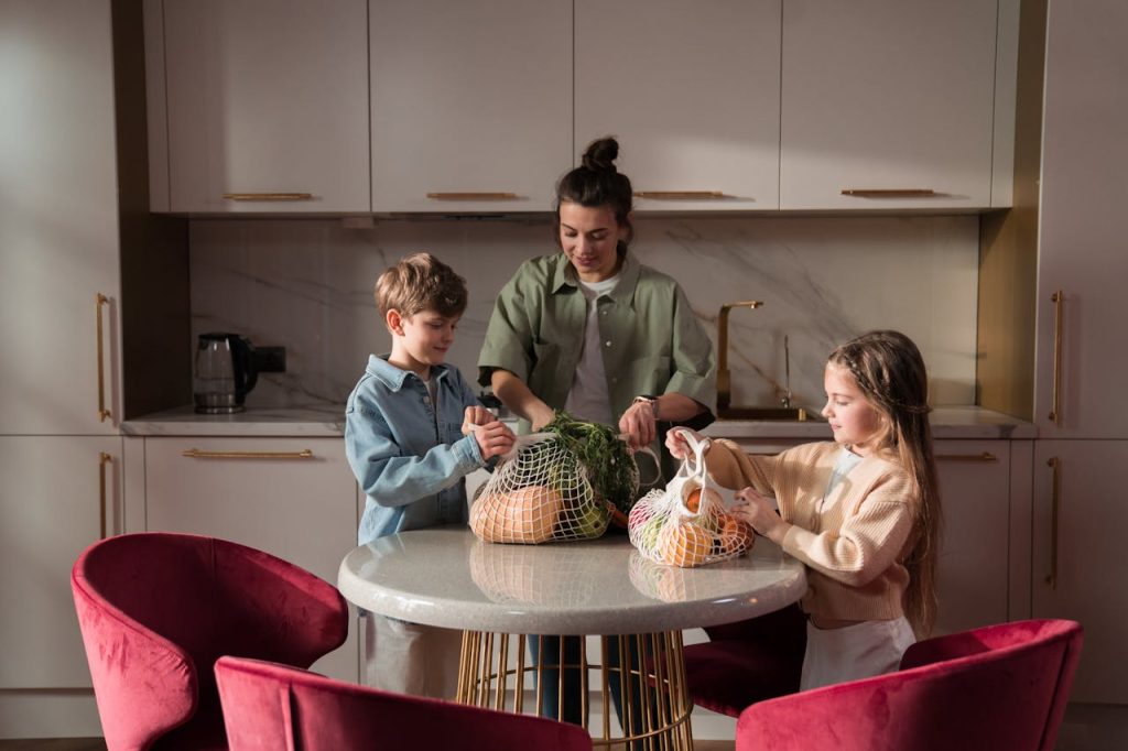 Mother and children unpack fresh vegetables in a modern kitchen, promoting family togetherness and a healthy lifestyle.